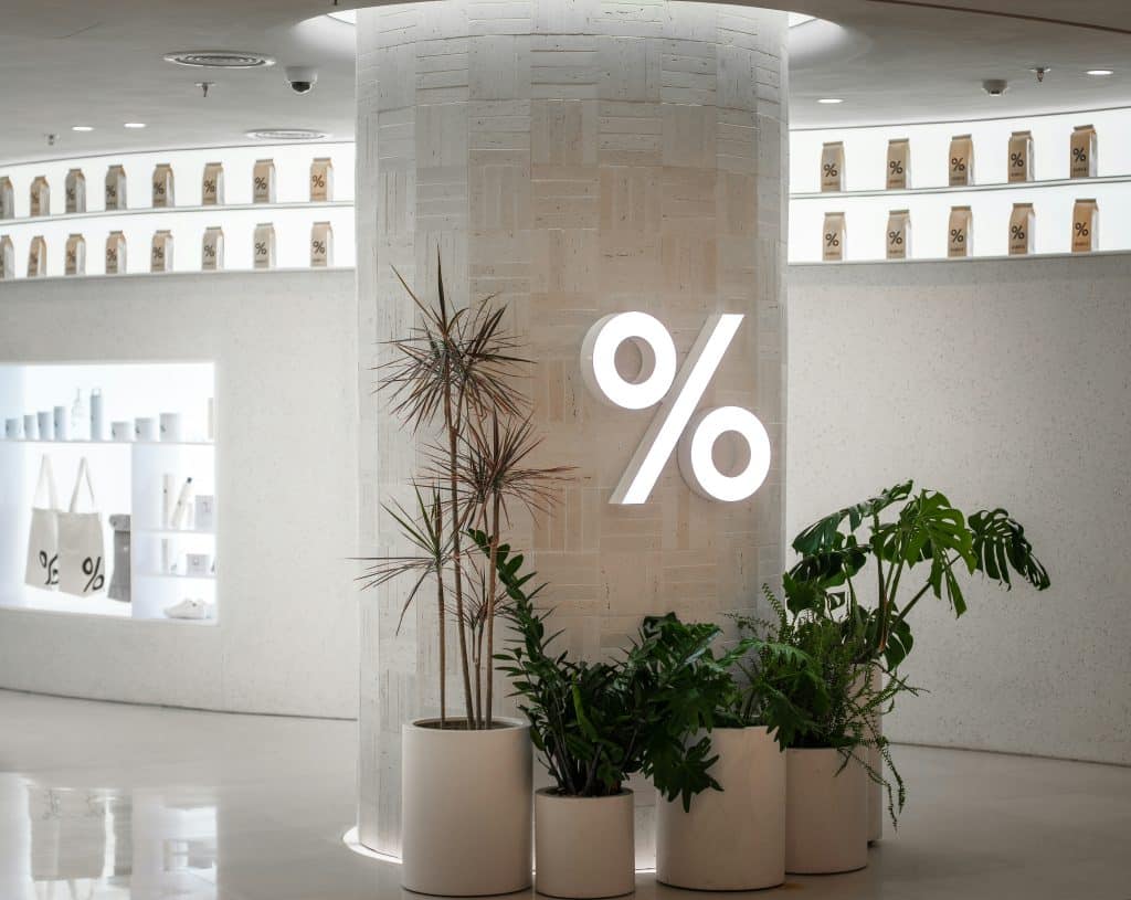 percentage sign on office wall with pot plants