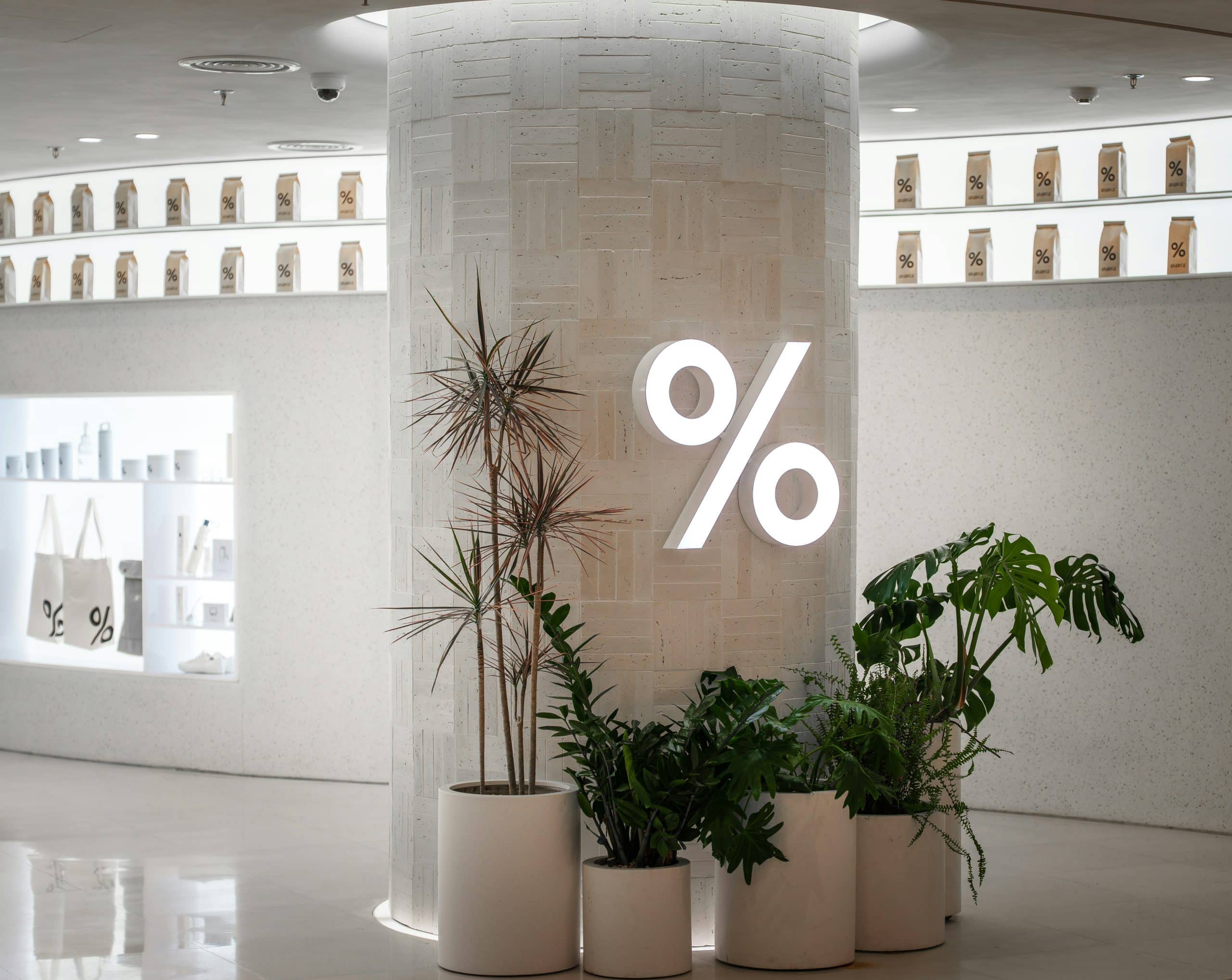 percentage sign on office wall with pot plants